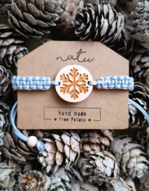 Drewniana bransoletka z grawerowaną śnieżynką na ręcznie plecionym sznurku.