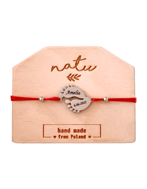 Personalizowana bransoletka na czerwonym sznurku z metalową stópką dziecka w srebrnym kolorze i grawerem imienia lub daty.